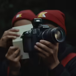 a person with a camera holding a box and taking a picture