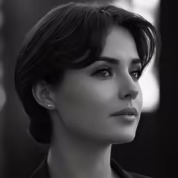 a close up view of a woman wearing a suit and bow tie