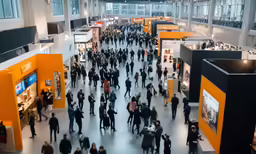 many people walk around a large yellow exhibition