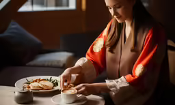 a woman is setting up a coffee and food dish