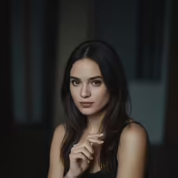 a woman posing for a portrait in a dark room