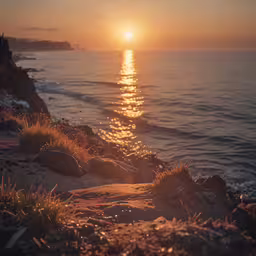 a beach and water with the sun reflecting off of the ocean