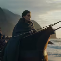 a woman wearing a blanket and riding on top of a horse