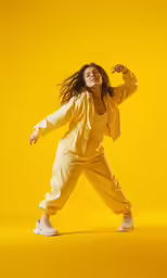 the young woman in yellow jumpsuit poses for the camera