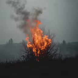 flames emitting out of a sky with hills behind them