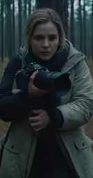 woman taking photograph in the woods with a large lens