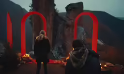 two people standing outside, illuminated by candles