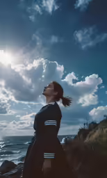 a woman with dark hair and a ponytail standing by the ocean