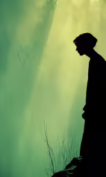 a man standing on top of a hill next to trees