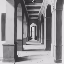 an empty hallway with arches and stone columns