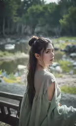 woman wearing long green dress sitting on park bench