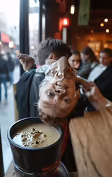 a child with an interesting face eating soup