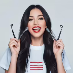 a model putting makeup on her eyelashes in a studio