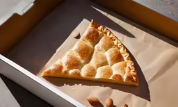 a half eaten slice of pastry next to almonds