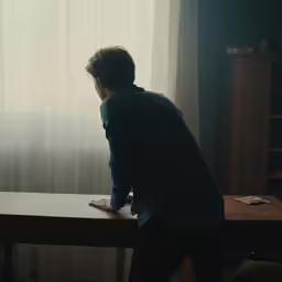 a man standing in front of a wooden table