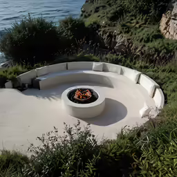 an outdoor fire pit with four round seats on concrete