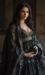 a woman is standing near a doorway, wearing a dress with gold and black designs