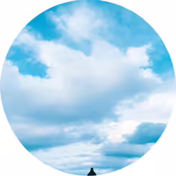 a man standing in a circle looking down at clouds