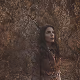 a woman with long hair is standing in a field