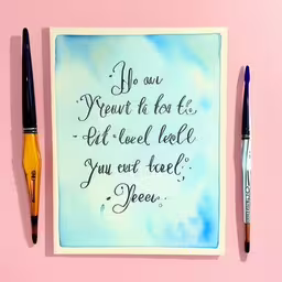 some pens are on a desk and a picture,some watercolors and pens sitting on a surface