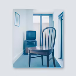 the blue rug is near the wooden chair in the room