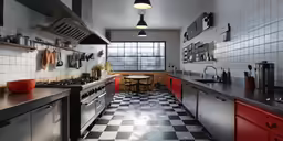 a kitchen with red cabinets and black counter tops