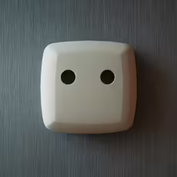 a white object with two hole holes in the middle