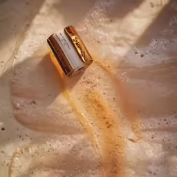 a close up of a gold and white pill on a surface