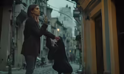 woman smoking cigarette walking along an old, gloomy street