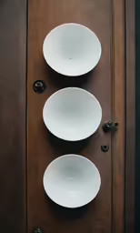 three bowls sitting on top of a brown board