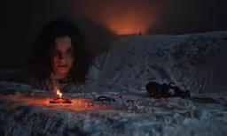 a girl is laying on the floor by the candle