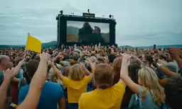 a group of people reaching their hands up to a large screen