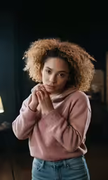 a woman with big hair standing in front of a table
