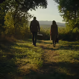 two people are walking in the woods holding their hands