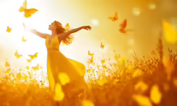 a woman in a field with a large yellow butterfly