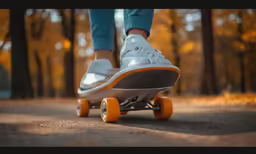 a person with sneakers and white shoes on an orange skateboard