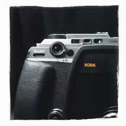 a close up image of a camera with an orange dot on the lens