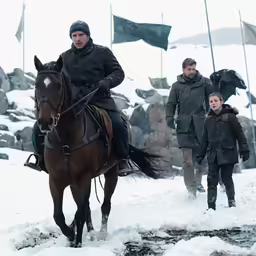 man and woman on horse going through snow