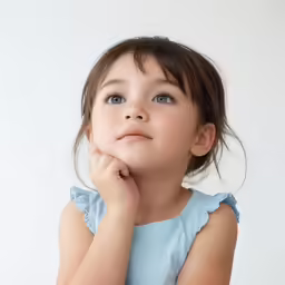 the little girl is staring up at something