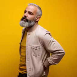 an old man in brown and yellow standing against a yellow background