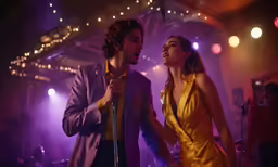 man in a yellow dress standing beside woman in a dark room