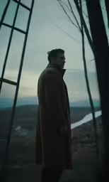 a man in a trench coat stands near a ladder