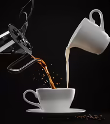 a pitcher pouring a cup of coffee into a mug