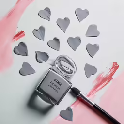 a lipstick in the shape of hearts with pink background