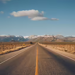 a deserted road with a view of mountains