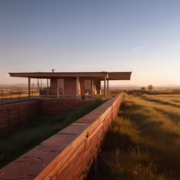 a house sits on a wooden fenced in ranch with grass surrounding it
