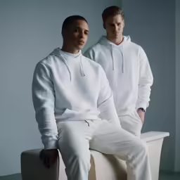 two males are wearing sweatshirts and white pants