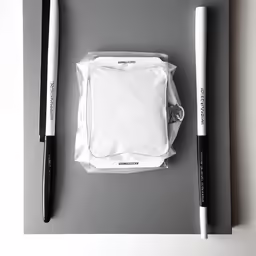an empty square white piece of cloth, two pens and a pair of scissors