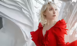 the woman is posing in front of white sheets
