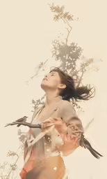 a woman standing next to a tree holding two birds on her arm